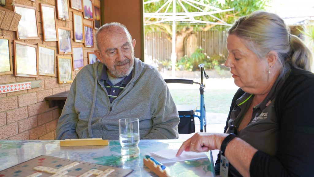 Burnie Brae Home Care Package Client Kaja playing scrabble with support worker at his home in Brisbane